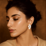 Model wearing Celestia Pearl Bloom white gold earrings styled for delicate floral sophistication.

