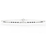 Angled view of white gold mangalsutra bracelet featuring diamond setting and black beads on sleek polished band.
