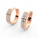 Angled view of rose gold oval hoops showcasing polished finish and channel set lab grown diamonds.
